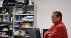 Shannon from UCP of Eastern Connecticut stands in front of the device lending library with a smile.