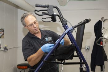 NEAT Center staff refurbishing a walker as part of their Equipment Recycling Program